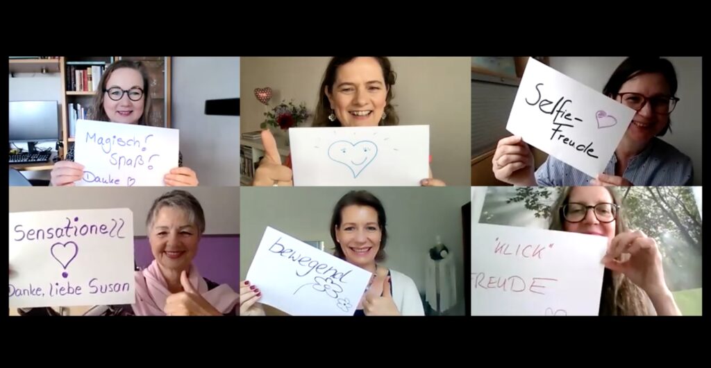 sechs Frauen halten Feedback-Schilder in die Kamera
